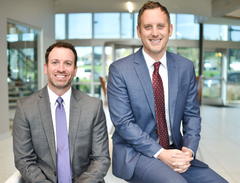 two men in suits posing for a picture